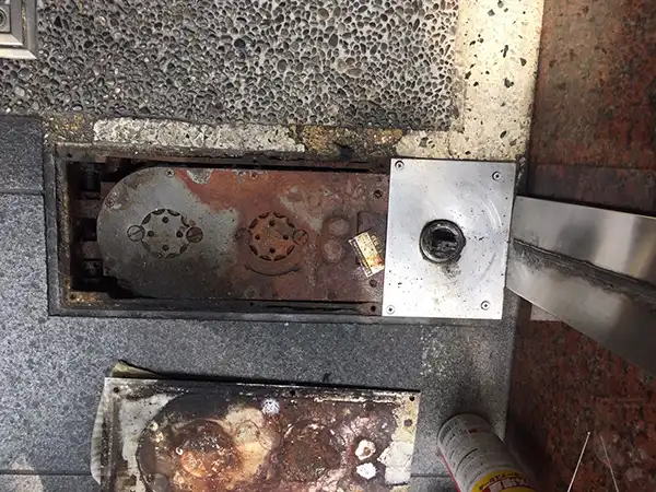 扉を外してフロアヒンジの蓋を取り外しました。錆びています。